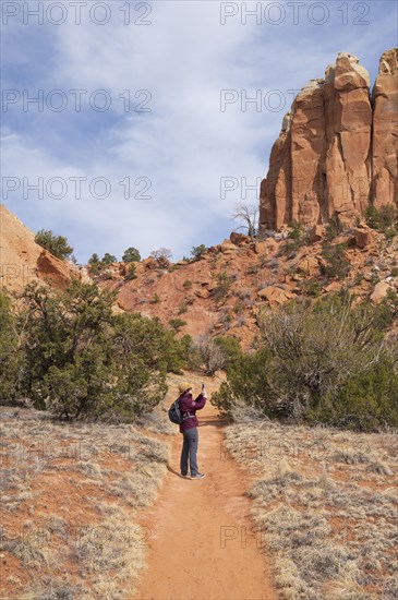 Female hiker photographing mesa in desert landscape