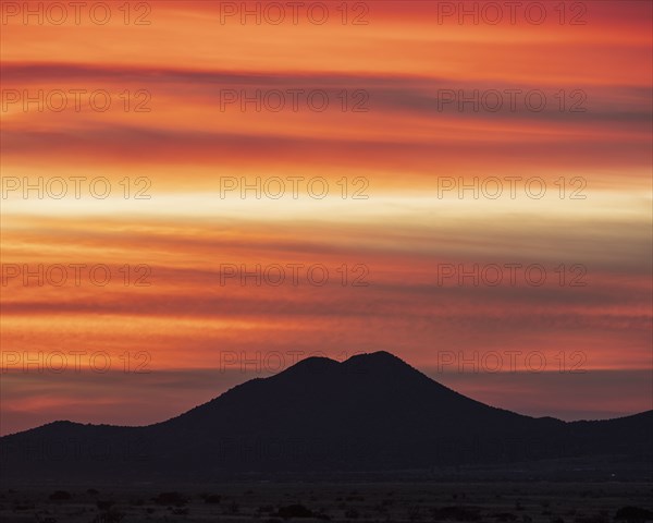 USA, New Mexico, Santa Fe, Silhouette of mountain against orange sky at sunset