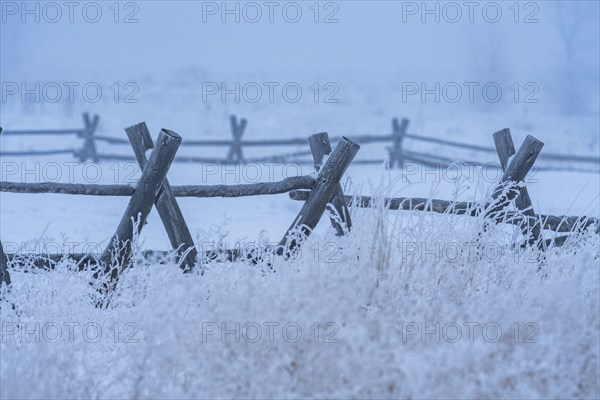 Wooden fence in snow covered field