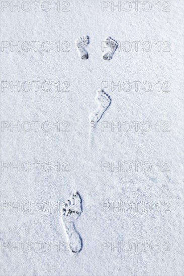 Overhead view of bare footprints in fresh snow