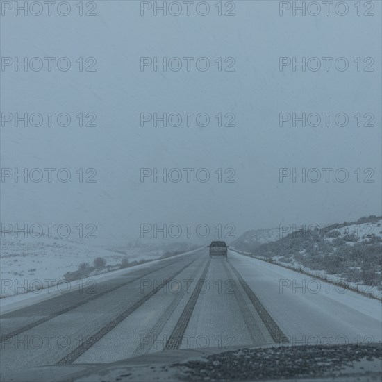 Snow covered rural road seen from car