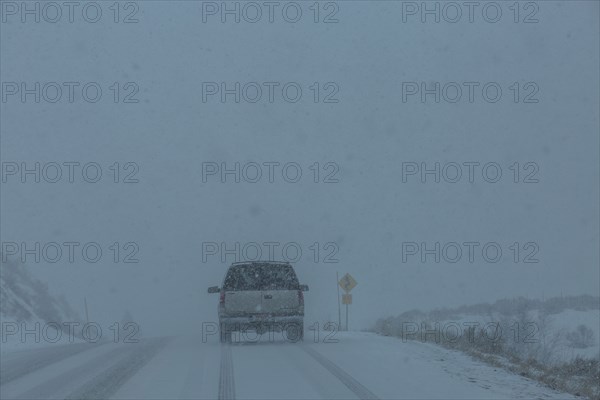 Pick-up truck on snow covered highway 20 in rural landscape