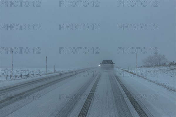 Pick-up truck on snow covered highway 20 in rural landscape