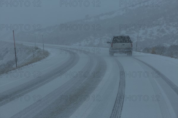 Pick-up truck on snow covered highway 20 in rural landscape