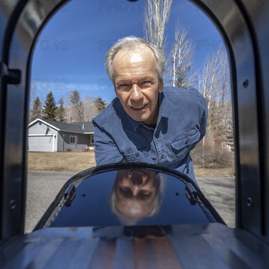 Senior man looking into mailbox