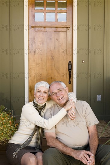 Happy couple embracing in front of house