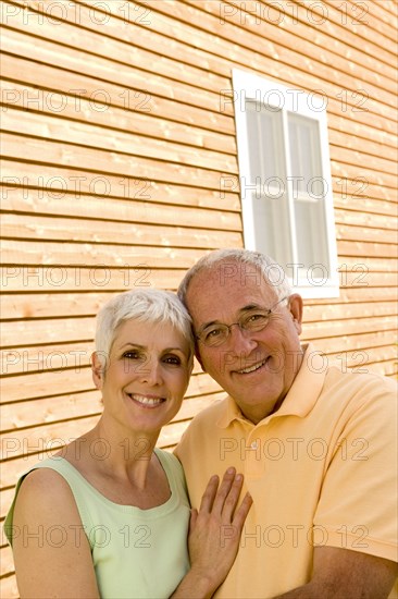 Happy couple embracing in front of house