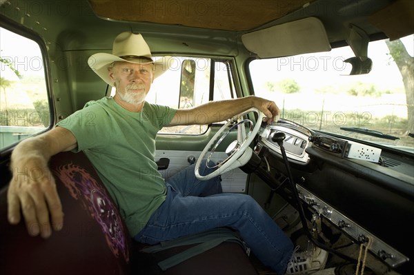 Man wearing cowboy hat in pick-up truck