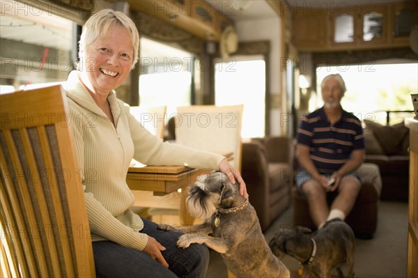 Senior couple wit dog in mobile home