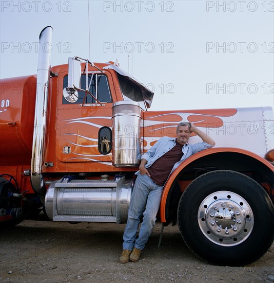 Truck driver leaning on his vehicle