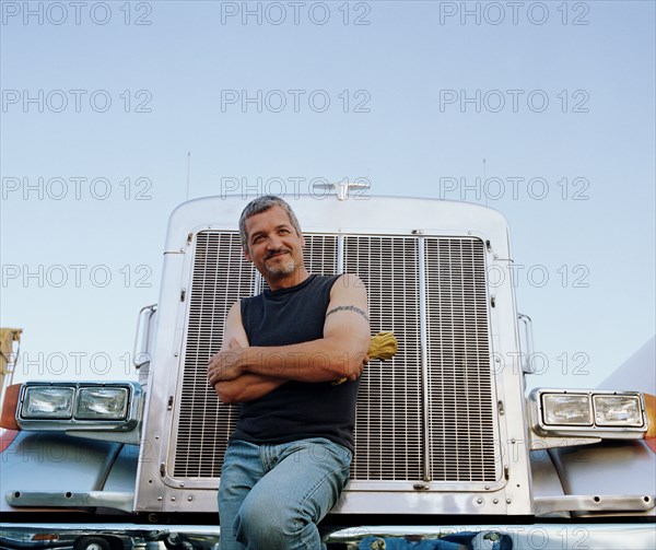Truck driver leaning on his vehicle