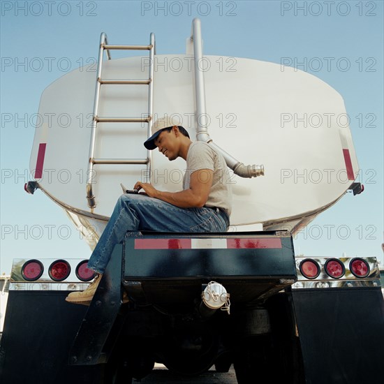 Truck driver sitting on his vehicle