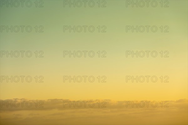 Golden sky at sunrise with low clouds below