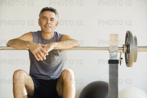 Portrait of man sitting on weight bench