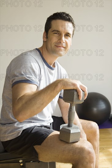 Portrait of man holding dumbbell