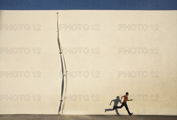 Man escaping by climbing rope over wall