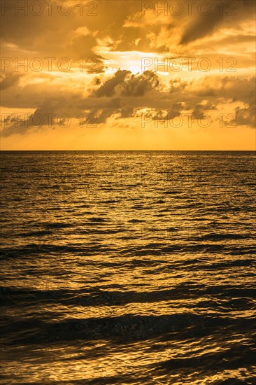 Orange clouds over ocean at sunrise