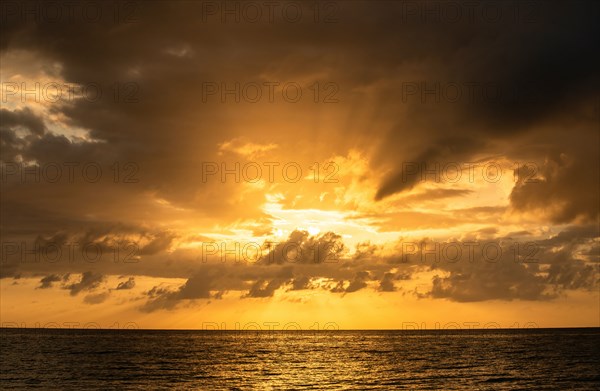 Orange clouds over ocean at sunrise