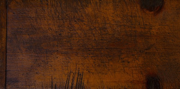 Close-up of worn antique cutting board with knife cut marks