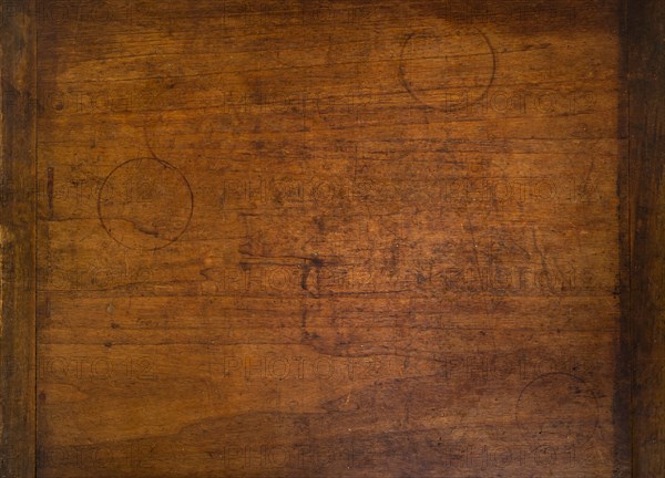 Close-up of worn antique cutting board with drinking glass rings