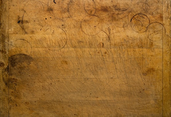 Close-up of worn antique cutting board with knife cut marks and glass rings