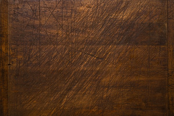 Close-up of worn antique cutting board with knife cut marks