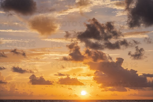 Golden clouds over ocean at sunrise