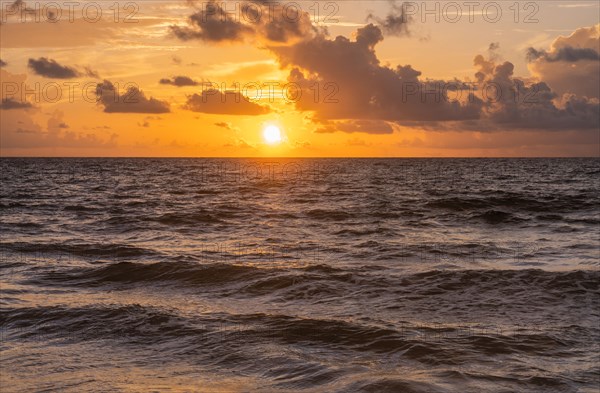 Golden clouds over ocean at sunrise