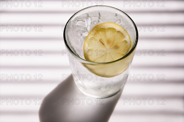 High angle view of club soda with ice and lemon
