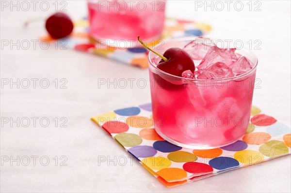 Red mocktail with cherry on colorful napkin