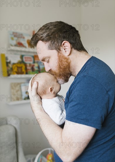 Father kissing newborn son