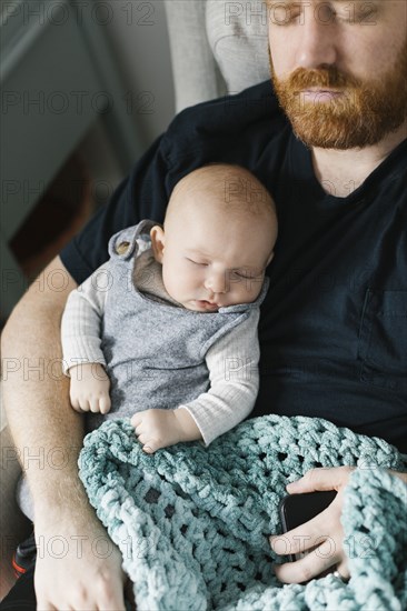 Father sleeping with newborn son