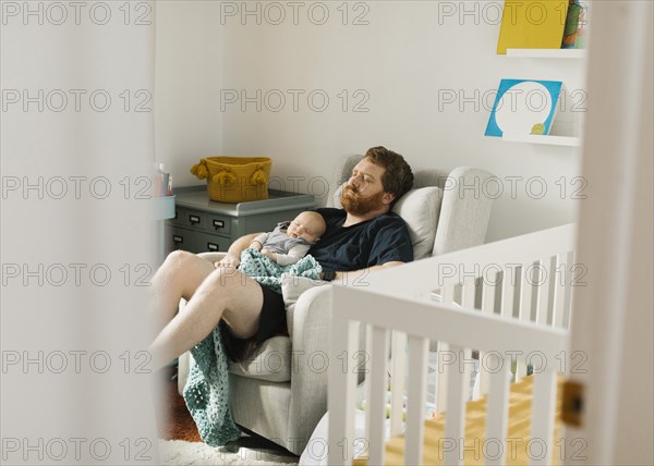 Father sleeping with newborn son