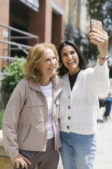 Smiling female friends taking selfie