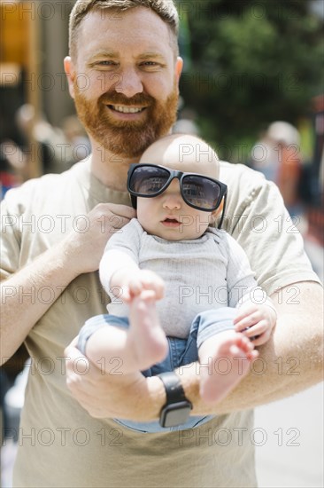 Portrait of father holding baby son