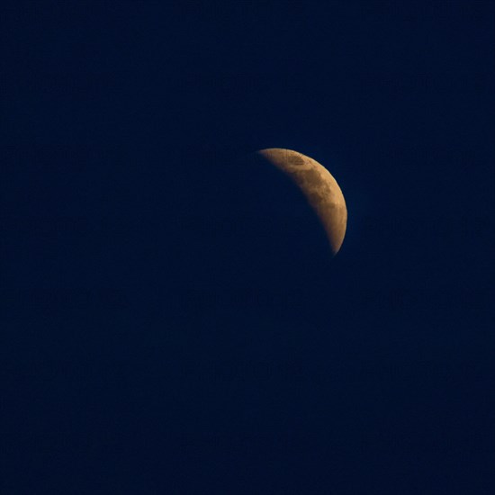 Moon rising in dark sky