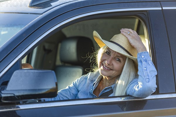 Blonde woman in car wearing cowboy hat