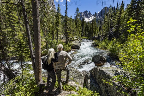 Senior couple standing next to rushing stream near Sun Valley