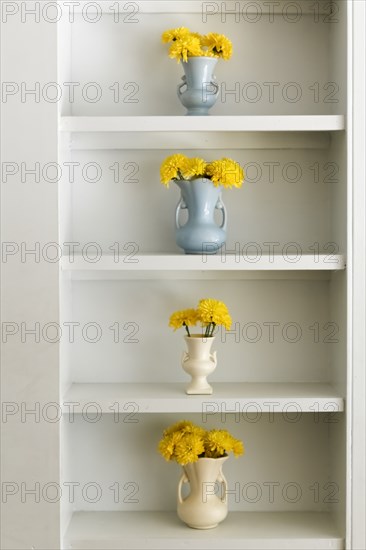 Shelf with vases and yellow flowers