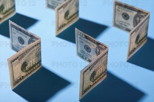 Folded twenty dollar bills against blue background