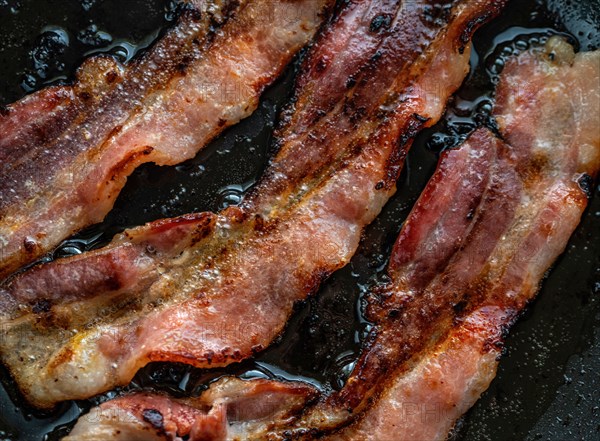 Close-up of bacon slices on frying pan