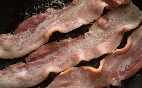 Close-up of bacon slices on frying pan