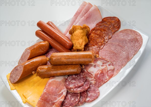 Plate filled with unhealthy processed meats and cheese