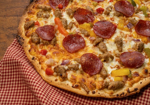 Pizza on wooden table with red check cloth