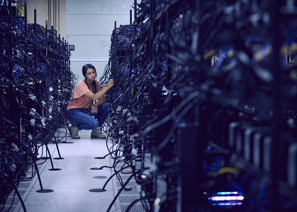 Female technician working in server room