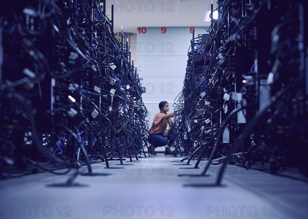 Female technician working in server room