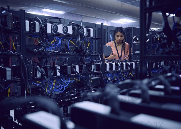 Female technician working in server room