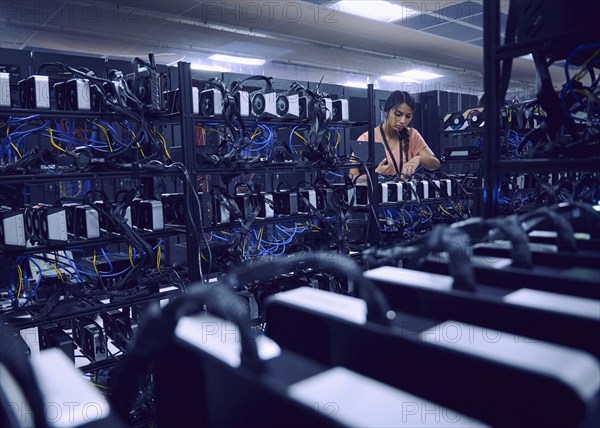 Female technician working in server room