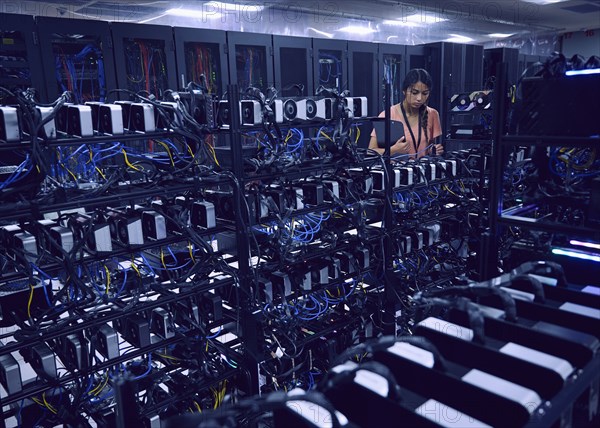 Female technician working in server room