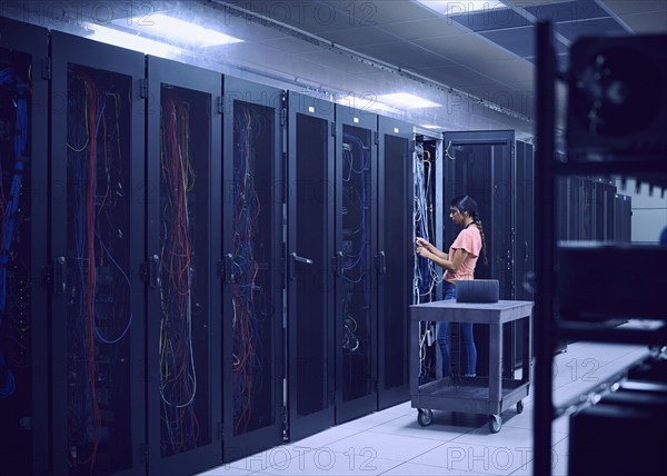 Female technician working in server room